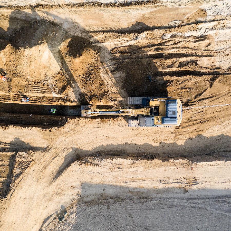Aerial view of Turf Construction Caterpillar 336 excavator digging underground utility trench.